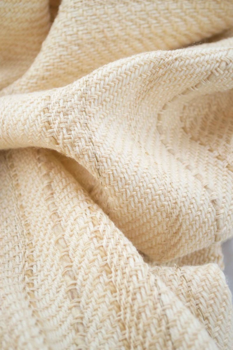 Throw blanket created with ivory cashmere, Pinkish beige silk, silk floss, cashmere, ecru wool, plus a few threads of linen and beige cotton slid into the plaid. Irregular fine band work.  Technique: Throw blanket hand-woven in a traditional way on non-mechanical looms in the 7th arrondissement of Paris in France.  Finishes: Right edge. Double stitching. 4 pompoms of silk and cashmere of 7,09 inches long.  Size: 57,09 x 66,93 inches.  Single piece / 1 copy only.