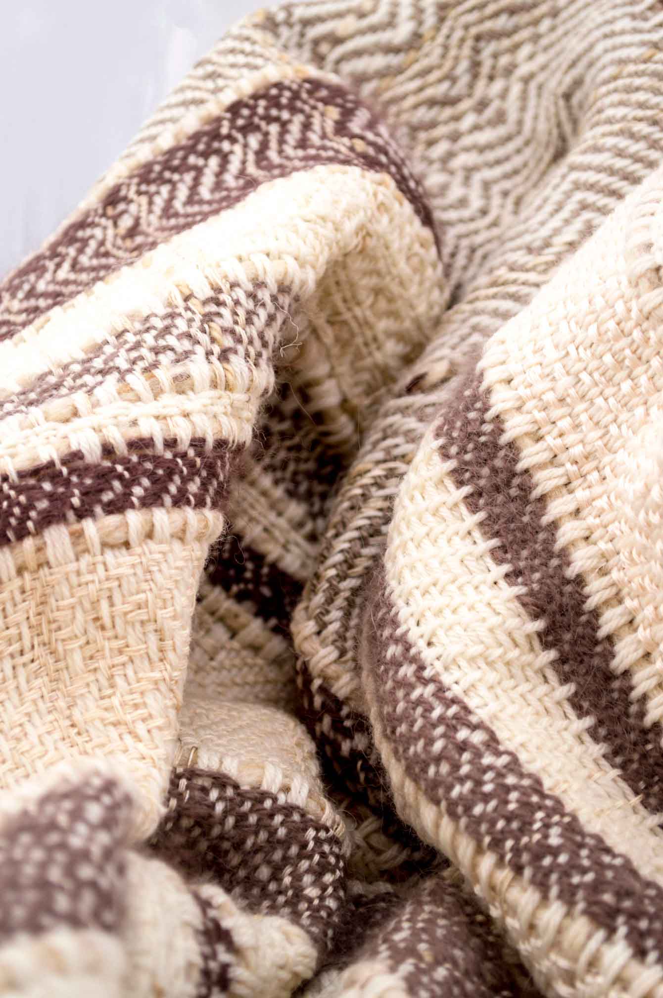 Throw blanket created with brown and taupe angora wood, pinky beige silk floss, silk, cashmere, country wool, ecru wool, and beige cotton threads slipped into the plaid.   Technique: Throw blanket hand-woven in a traditional way on non-mechanical looms in the 7th arrondissement of Paris in France.  Finishes: Right edge. Double stitching.  Size: 145 x 180 cm.  Single piece / 1 copy only.