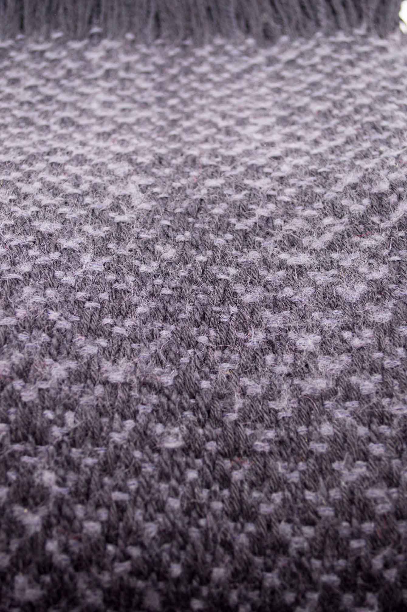 Throw blanket created with blue lavender mohair, and black wool.   Technique: Throw blanket hand-woven in a traditional way on non-mechanical looms in the 7th arrondissement of Paris in France.  Finishes: Right edge. Double stitching. 2 edges with 9 cm high of wool fringes.  Size: 140 x 220 cm.  Single piece / 1 copy only.