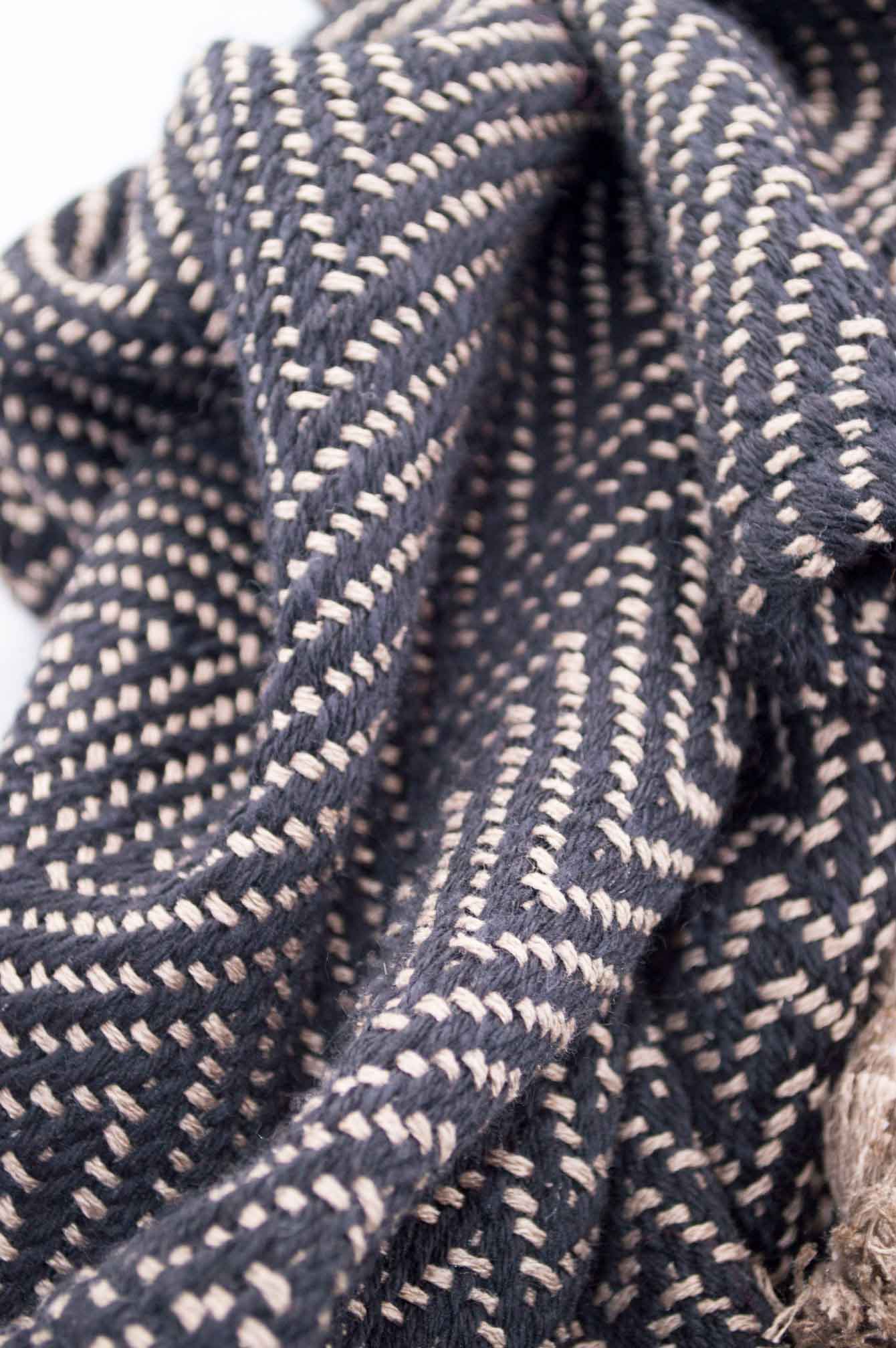Throw blanket created with sand silk floss, and black wool. Chevrons patterns.  Technique: Throw blanket hand-woven in a traditional way on non-mechanical looms in the 7th arrondissement of Paris in France.  Finishes: Right edge. Double stitching. 4 pompons of 20cm long.  Size: 140 x 190 cm.  Single piece / 1 copy only.