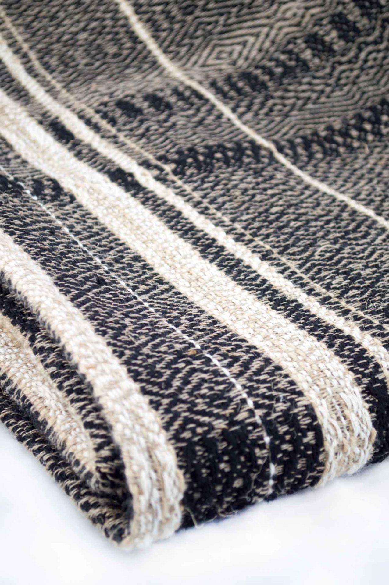 Throw blanket created with hemp, wool, linen. Union of different patterns and natural materials for the pleasure of the eyes.  Technique: Throw blanket hand-woven in a traditional way on non-mechanical looms in the 7th arrondissement of Paris in France.  Finishes: Right edge. Double stitching.  Size: 145 x 200 cm.  Single piece / 1 copy only.